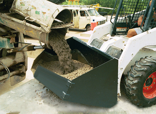Ready-mix truck chute loading concrete into the placement bucket on a skid steer