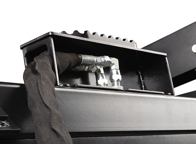 Inside the grapple bucket showing the hydraulic hoses running in their covered channel above the punched cutting edge