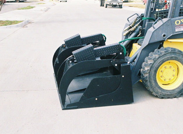 Grapple bucket on a skid steer with diamond plate arm tops closed down onto the bucket