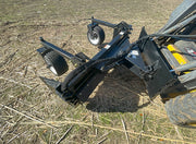 Power rake angled on its pivot, the debris curtain and drum visible from the front