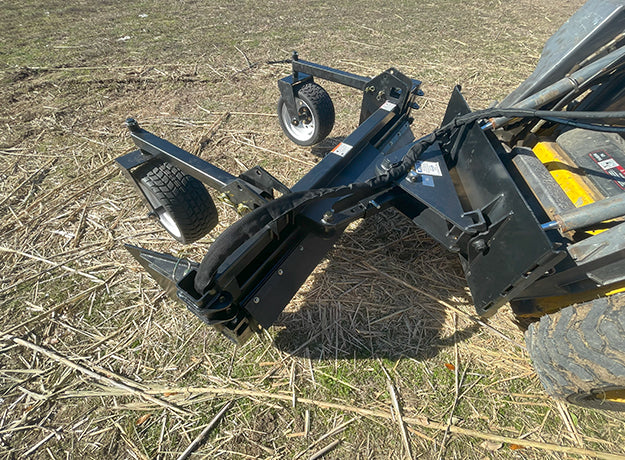 Power rake angled on its pivot, the debris curtain and drum visible from the front