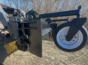 Close-up of a power rake gauge wheel on its swing arm beside the removable side plate