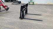 Storm 2000 pallet forks on pavement with a red loader behind, angled view