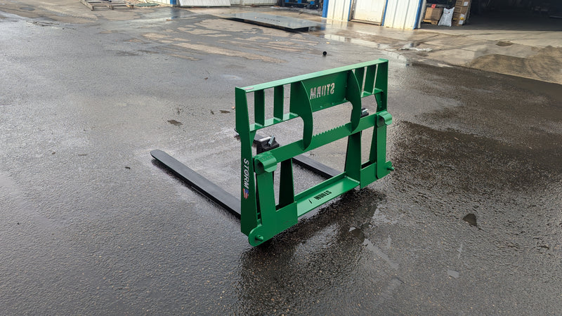 Storm 4500 pallet forks in John Deere green, three-quarter view across the frame and the fork hooks