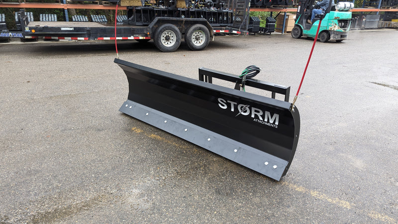 Storm angle snow blade on pavement by a trailer, side view showing the cutting edge and moldboard