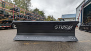 Storm angle snow blade on pavement, head-on view across the full width of the moldboard and cutting edge