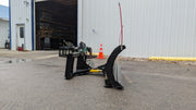 Storm angle snow blade angled on pavement beside a building, three-quarter view of the blade and frame