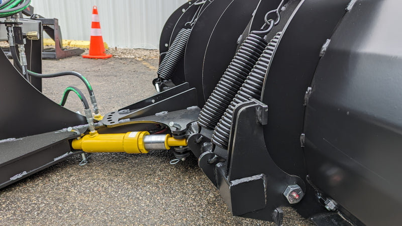 Storm angle snow blade, close view of the trip springs and the yellow angle cylinder behind the moldboard
