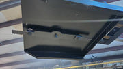 Storm 60 inch brush cutter, underside view of the deck showing the blade bar and the stump jumper
