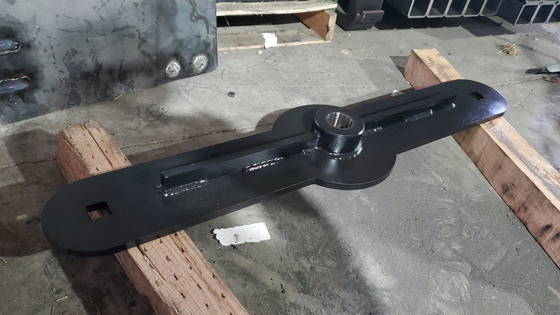 Storm 60 inch brush cutter blade carrier on timbers, showing the twin blade slots and the central hub