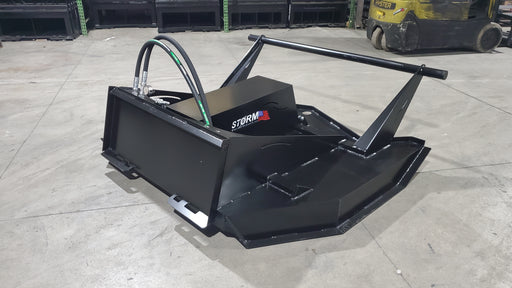 Storm 72 inch HD brush cutter on a warehouse floor, three-quarter view showing the flip-up shroud, push bar, and coiled hydraulic hoses