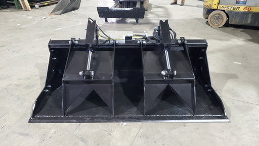 Storm HD grapple bucket on a shop floor, front view with the clamp raised over the open bucket