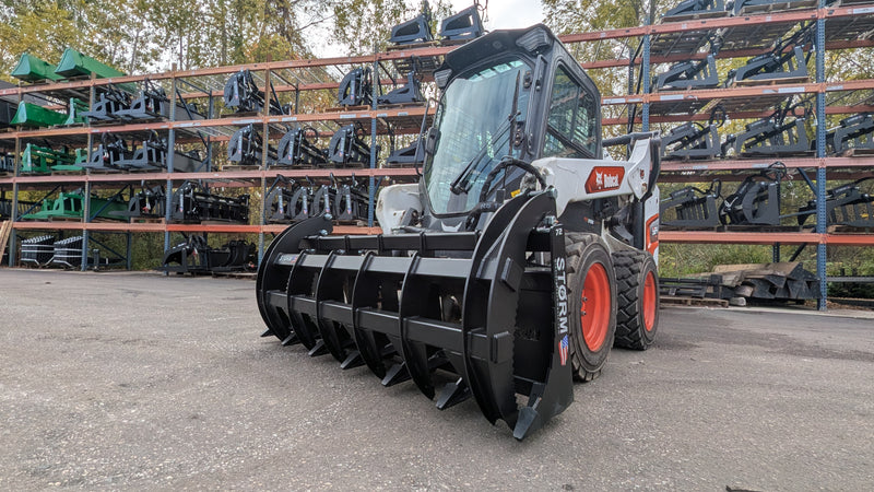 Storm HD rake and brush grapple mounted on a white skid steer, side view on a gravel yard