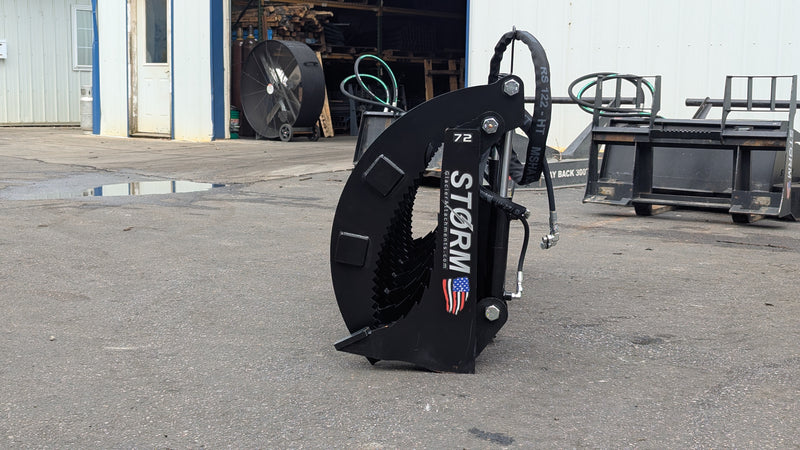 Storm 72 inch HD rake and brush grapple stood on end, side view of the curved arm profile and the stacked tines