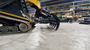 Storm 72 inch HD rake and brush grapple on a track loader in a shop, low view along the closed tines