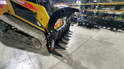 Storm 72 inch HD rake and brush grapple on a yellow track loader, angled view down the tine bar