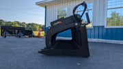 Storm HD root and brush grapple, side profile on pavement showing the tall clamp arm and spaced tines
