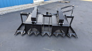Storm HD root and brush grapple, straight-on rear view across the frame and the twin arm cylinders