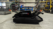 Storm 48 inch mini brush cutter from the side on a shop floor, showing the low deck profile and coiled hoses