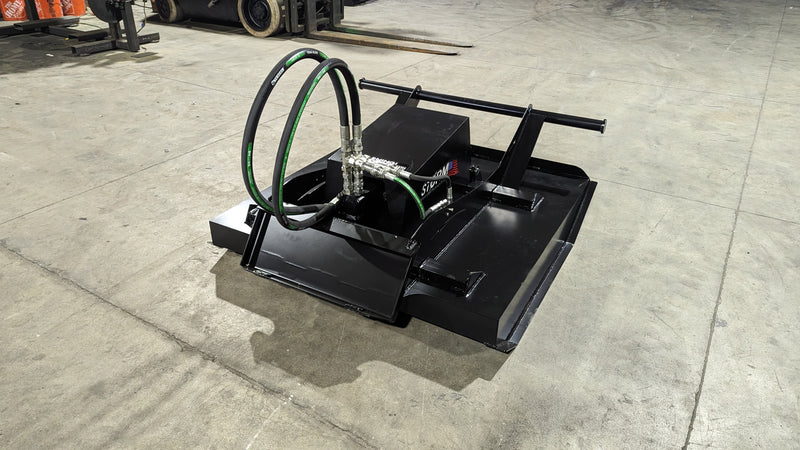 Storm 48 inch mini brush cutter from above on a shop floor, looking down onto the deck top and hose connections