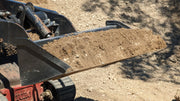 Storm mini bucket on a Toro Dingo track loader carrying a load of soil, side view of the filled bucket