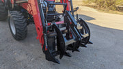 Storm rake and brush grapple on a red tractor loader, side view with the clamp closed over the tines