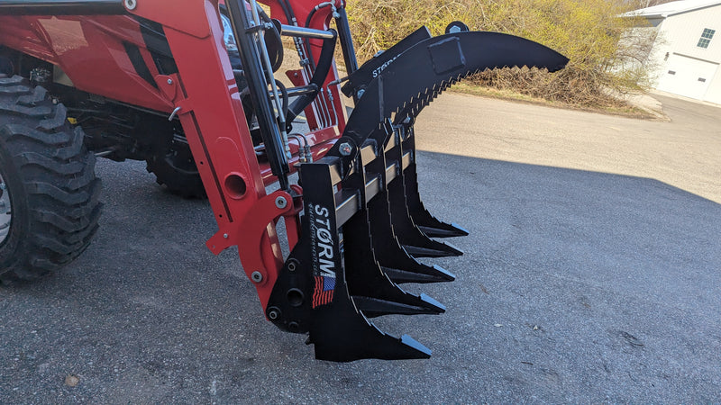 Storm 48 inch rake and brush grapple, angled view along the tines with the grapple arm raised