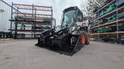 Storm rock and brush grapple on a Bobcat skid steer, three-quarter view of the tine bar and the twin arms