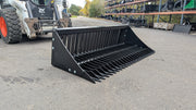 Storm rock bucket with a skid steer behind, angled view of the tines