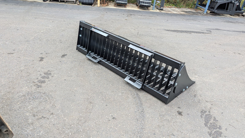 Storm rock bucket on pavement, angled view with the tines facing forward
