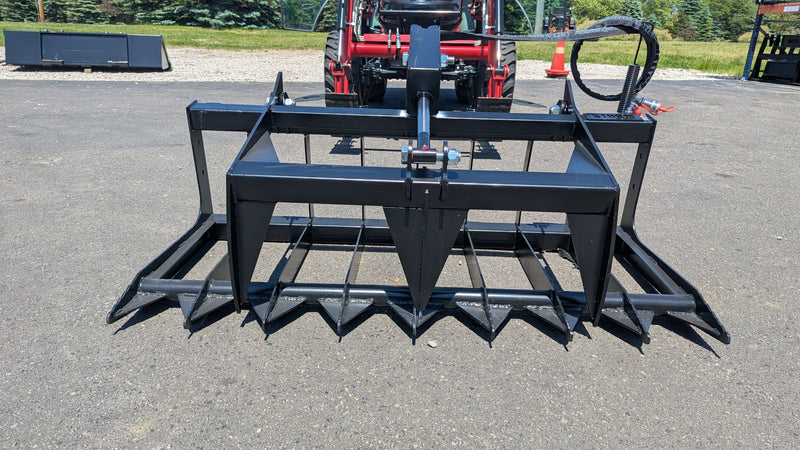 Storm root and brush grapple seen head-on across the full width of the spiked tine bank and top clamp