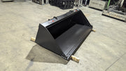 Storm skid steer bucket on a shop floor, three-quarter view of the shell