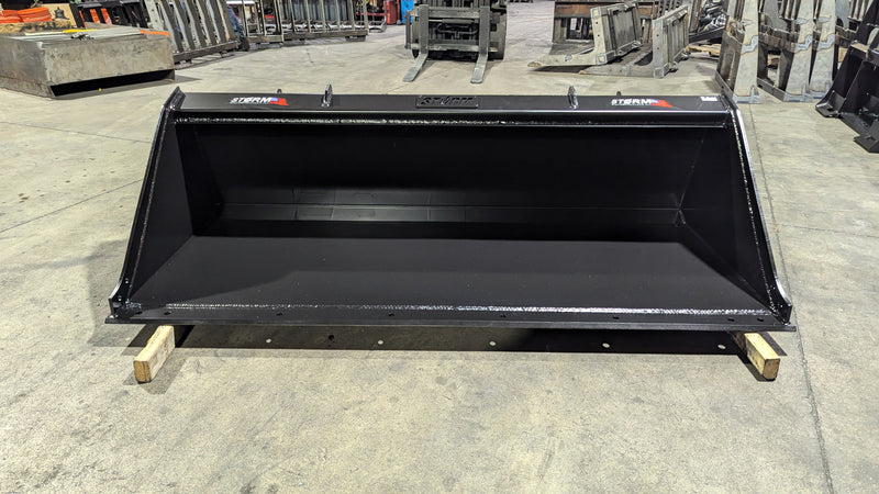 Storm skid steer bucket, front view across the wide smooth-edge opening