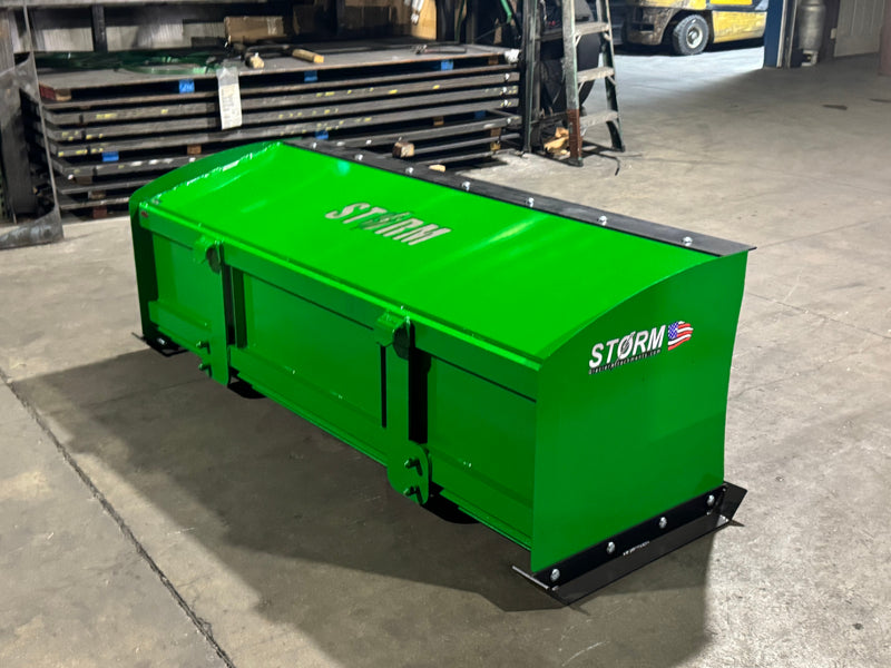 Storm snow pusher in John Deere green on pavement, showing the boxed pusher on the John Deere mount