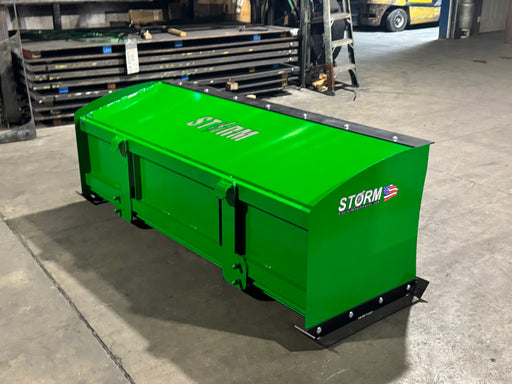 Storm snow pusher in John Deere green on pavement, showing the boxed pusher on the John Deere mount