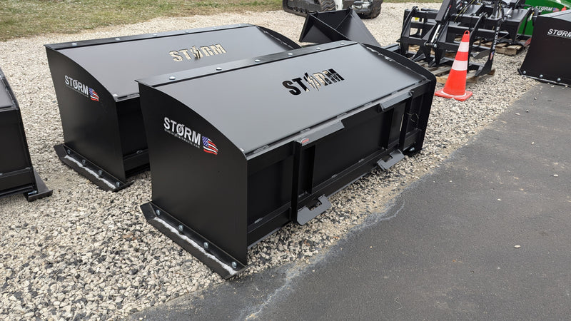 Storm box snow pushers on a gravel yard, three-quarter view of the enclosed moldboards