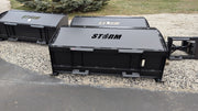 Storm snow pushers parked on gravel, three-quarter view of the boxed body and the top cap