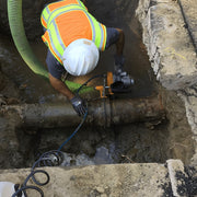 Operator cutting a main from above with the ACH-GB in an excavation