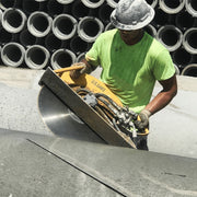 Operator cutting stacked concrete pipe with the hydraulic hand-held saw