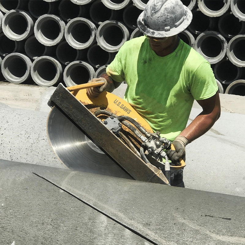Operator cutting stacked concrete pipe with the hydraulic hand-held saw