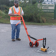 Operator positioning the curved steel dolly over a manhole cover
