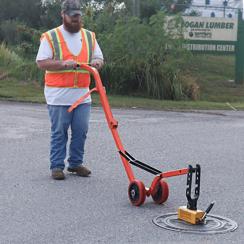 Operator positioning the curved steel dolly over a manhole cover