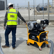 Operator wheeling the Ultra Vac 1250-G across a slab