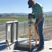 Operator running the VEX-400 on a valve box beside a rural road